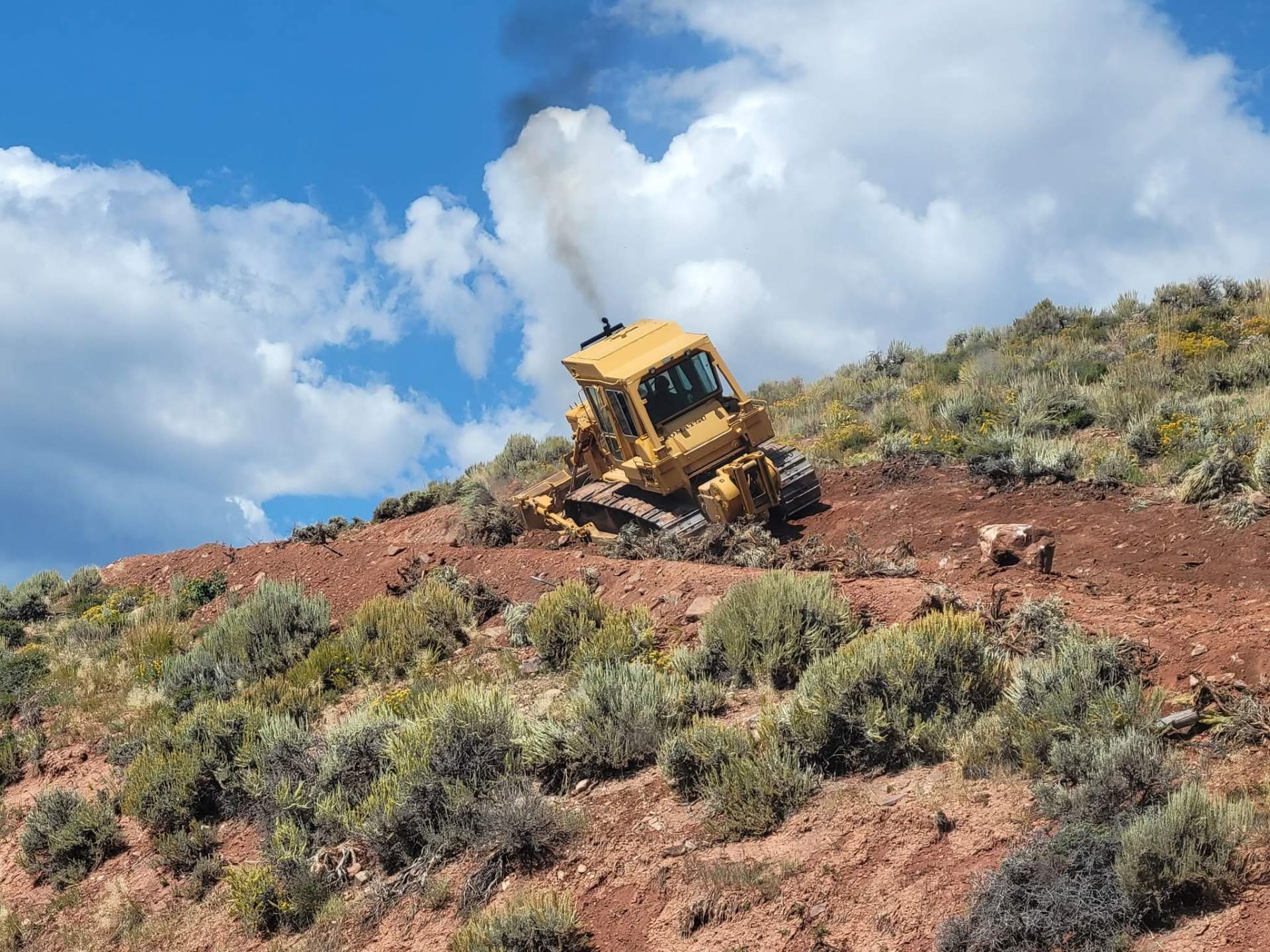 Buck's Trucks dozer pushing dirt on a Wyoming hillside