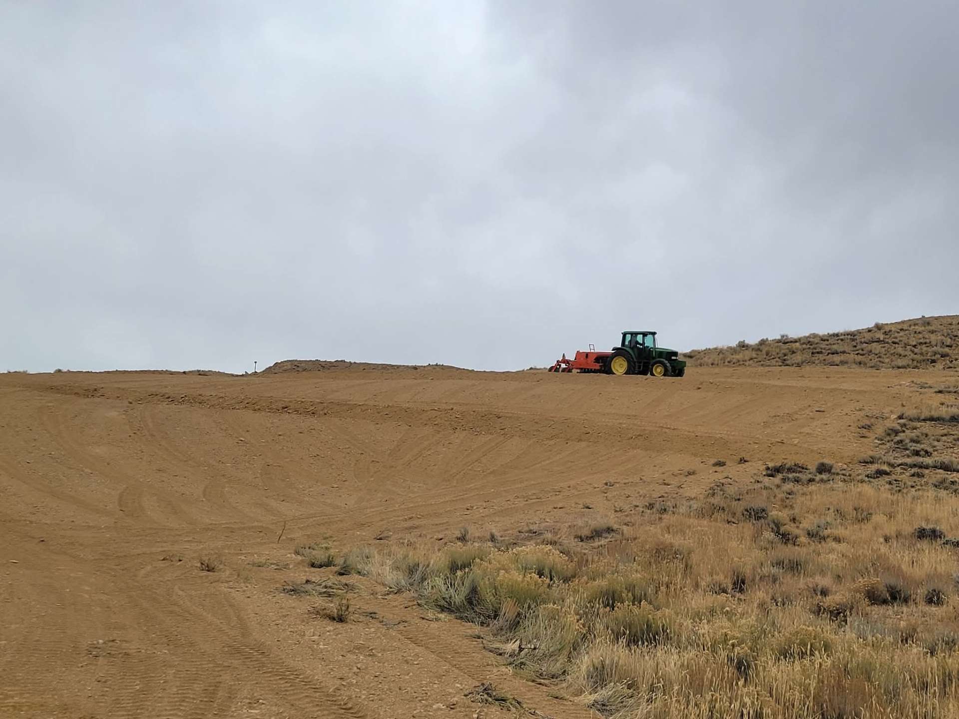 Reclaimed Wyoming oilfield location with fresh seeding under big sky